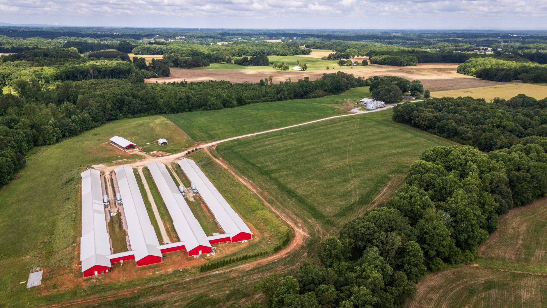Weathered ranch buildings and open acreage under a solar-panel array on a rural Washington property