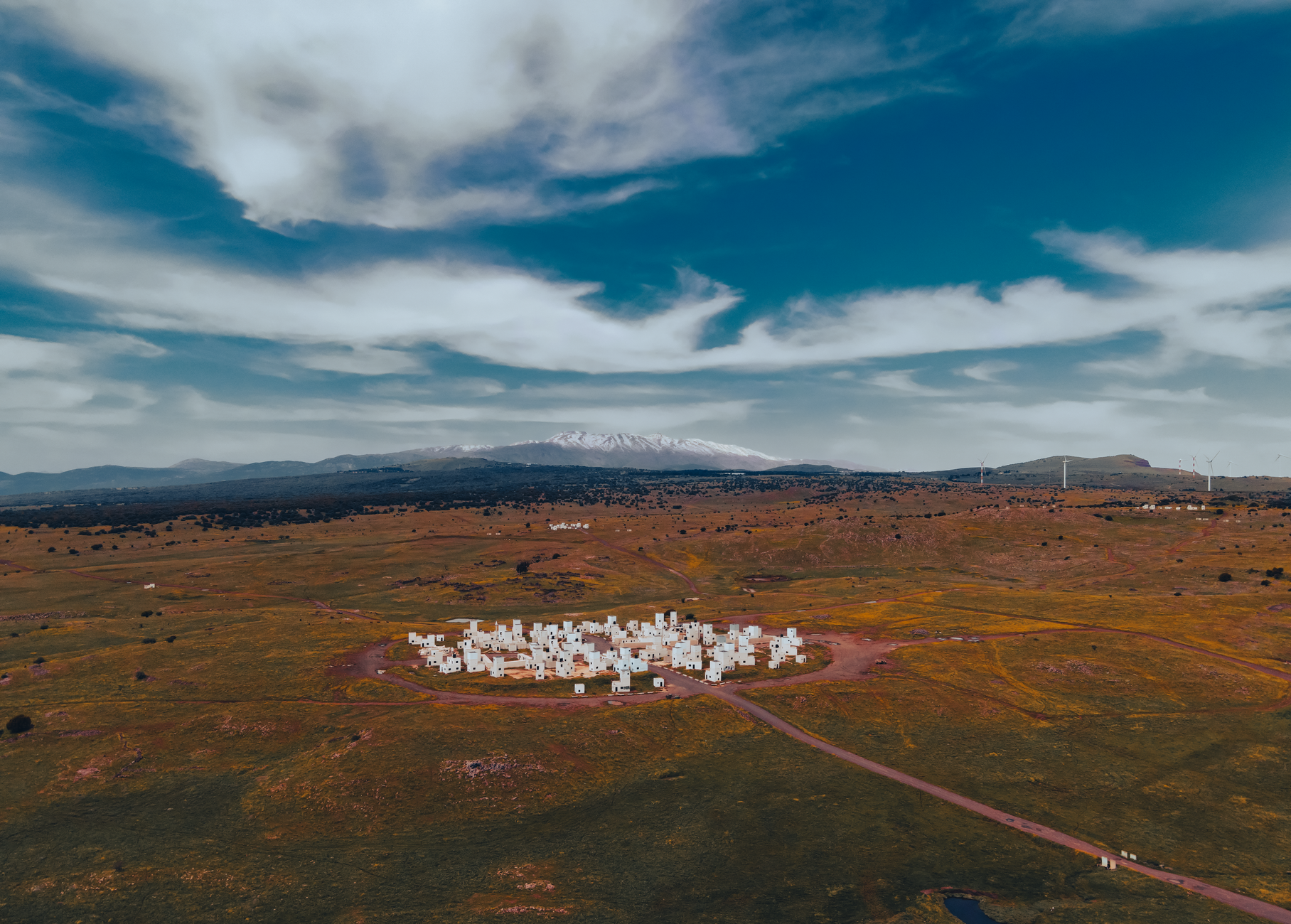 Cluster of low geometric desert homes beneath a wide Arizona sky